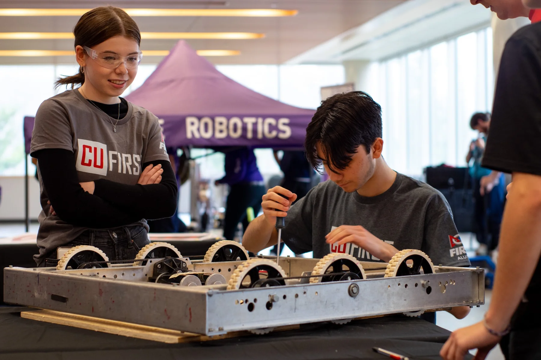 CU FIRST students working on a robot